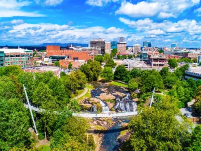 Aerial view of downtown Greenville South Carolina with Falls Park on the Reedy, Liberty Bridge, and surrounding real estate